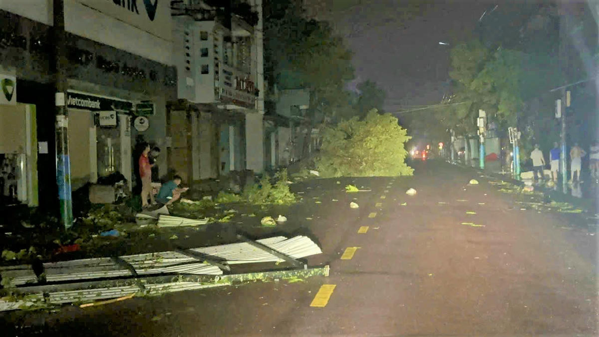 Một số người dân hiếu kì ra đường xem cây cối ngã đổ. Ảnh: Tấn Thành.