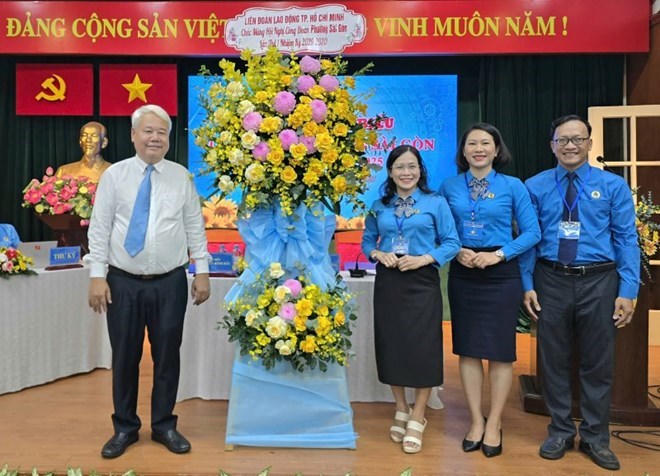Ông Võ Khắc Thái, Phó Chủ tịch Thường trực Liên đoàn Lao động TPHCM (bên trái) tặng hoa chúc mừng Công đoàn phường Sài Gòn. Ảnh: N. Dương