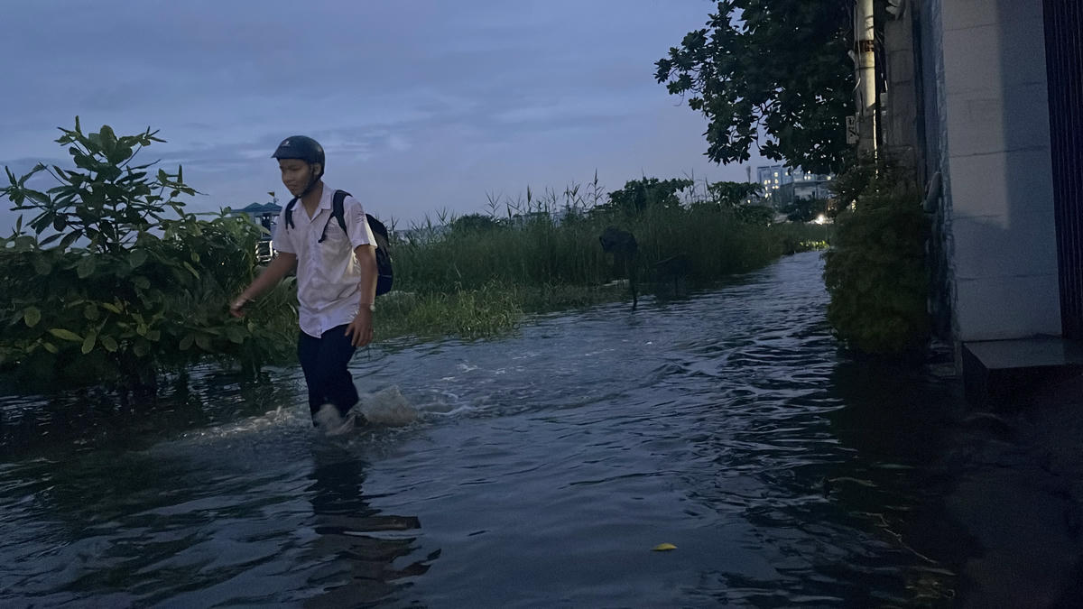 Học sinh lội nước về nhà vì xe bị chết máy. Ảnh: Đ.Xá.