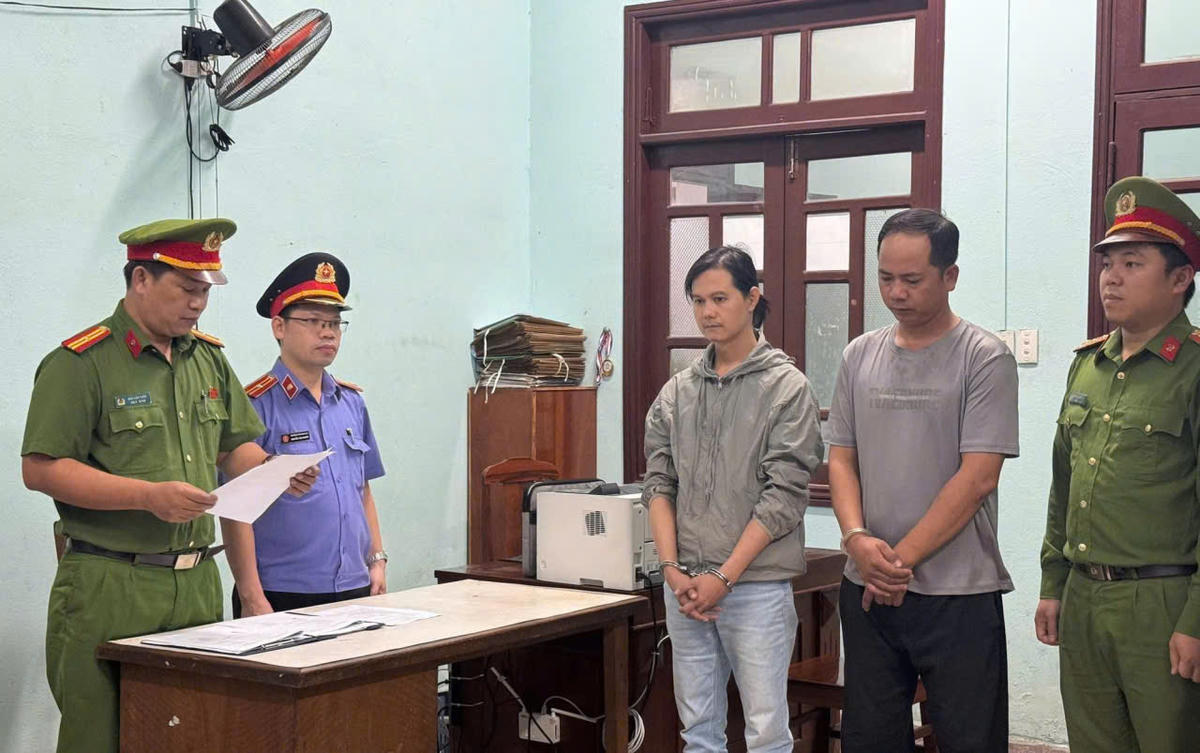 Lực lượng Công an phường An Khê đọc quyết định khởi tố 2 đối tượng hành hung tài xế xe công nghệ. Ảnh: Công an cung cấp.