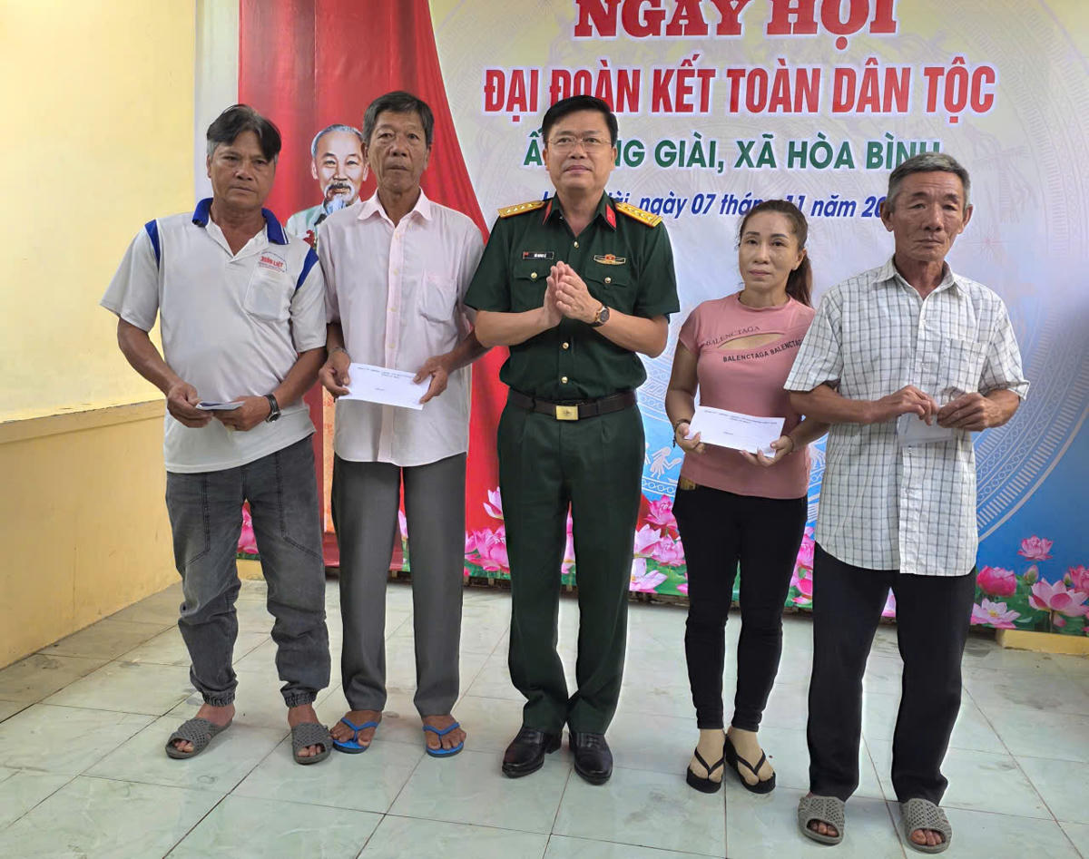 Đại tá Võ Thanh Lê, Chính ủy Bộ Chỉ huy quân sự tỉnh Cà Mau tặng quà cho các gia đình chính sách ấp Láng Giài. Ảnh: Nguyên Du