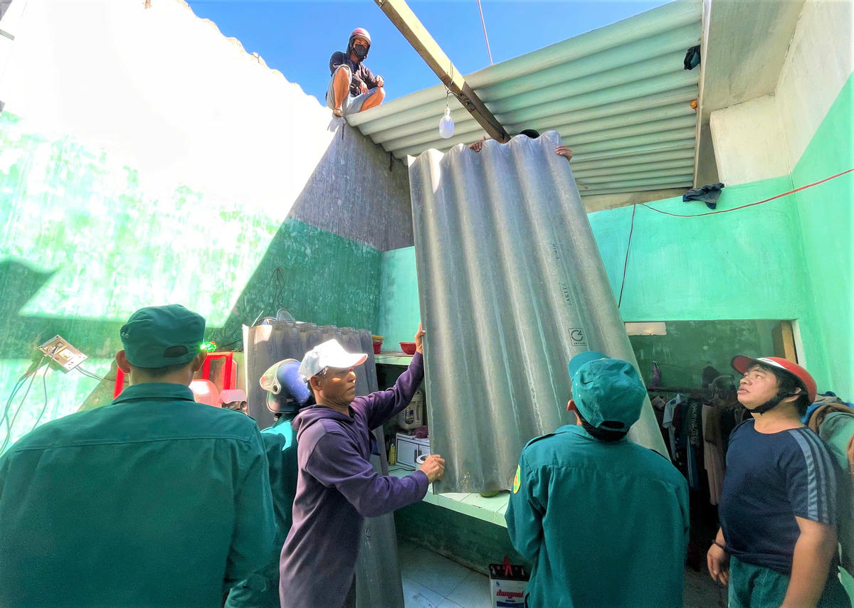 Lực lượng chức năng giúp dân lợp lại mái nhà. Anh: Chí Đại