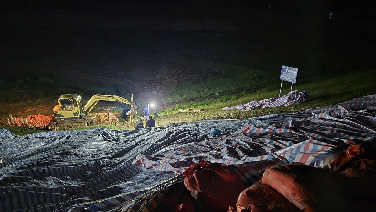 Toàn cảnh khu vực thân đập hồ Cay An được che phủ bạt và chiếu sáng khẩn cấp để gia cố, ngăn nguy cơ sạt, trượt trong đêm. Ảnh: TT.