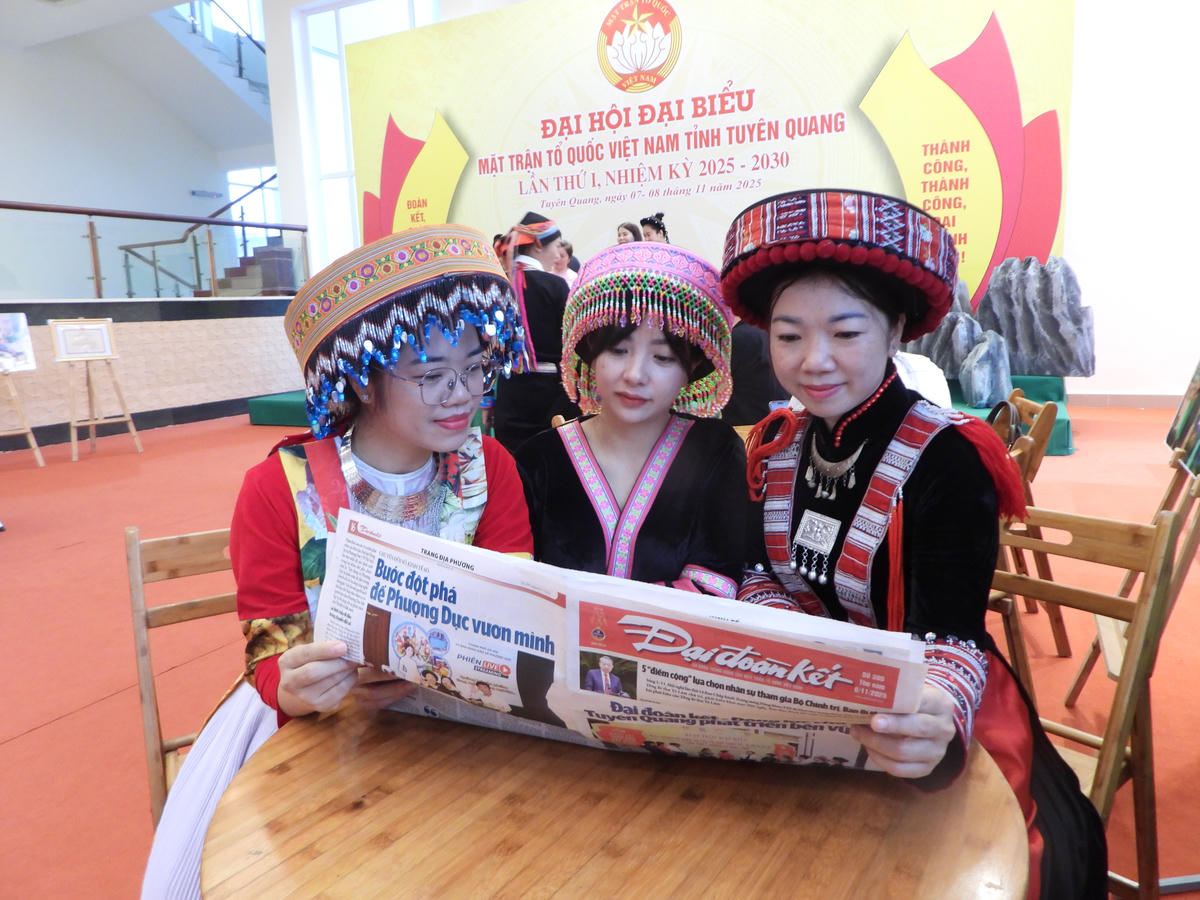 Các đại biểu chăm chú đọc báo Đại đoàn kết tại Đại hội. Ảnh: Đ.S.