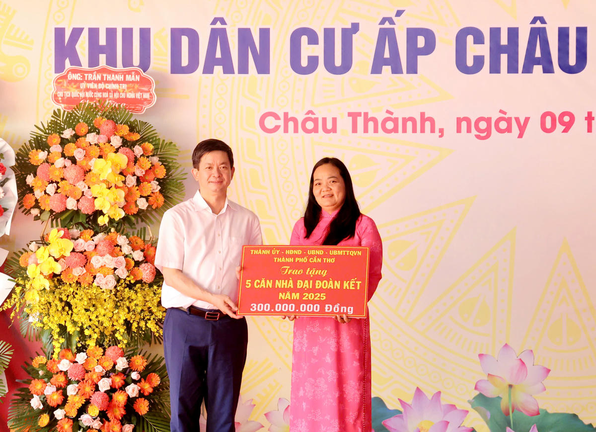 Bí thư Thành ủy Cần Thơ Lê Quang Tùng trao bảng tượng trưng hỗ trợ kinh phi xây nhà Đại đoàn kết. Ảnh Trung Phạm. 