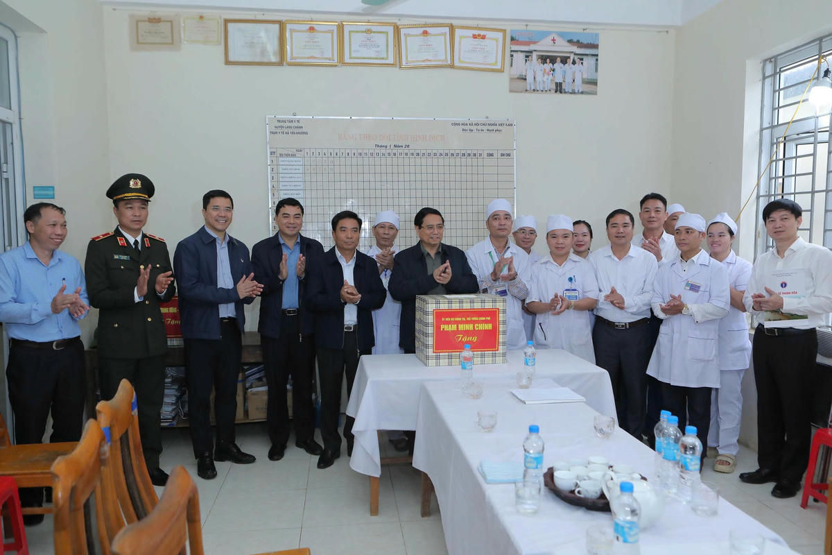 Thủ tướng Phạm Minh Chính tặng quà động viên cán bộ, nhân viên Trạm Y tế xã Yên Khương. Ảnh: Minh Hiếu