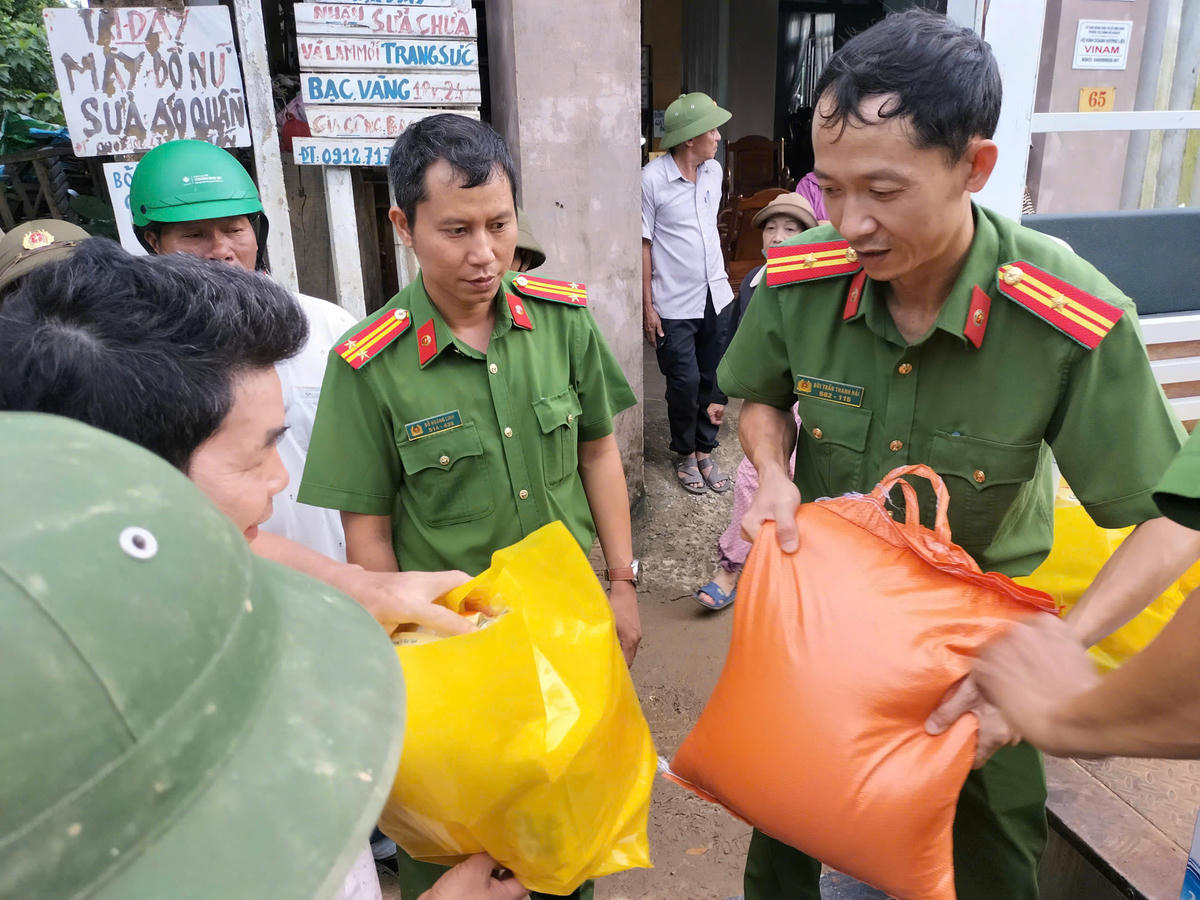Các chiến sĩ công an đến tận nhà trao quà cho người dân vùng lũ. Ảnh Phước Thành