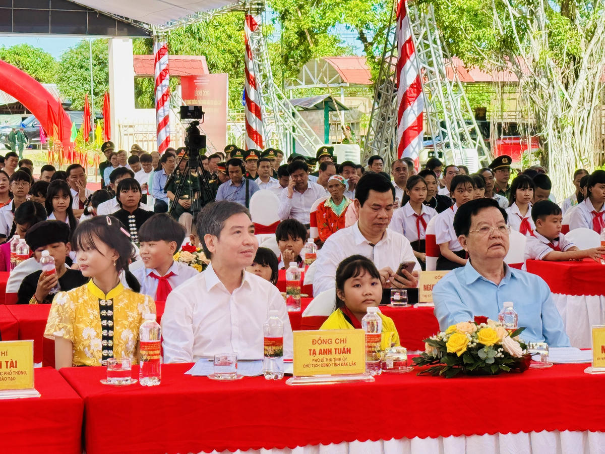Phó Thủ tướng Mai Văn Chính, Chủ tịch UBND tỉnh Đắk Lắk Tạ Anh Tuấn cùng học sinh xã Ia R'vê, Đắk Lắk. Ảnh: Thanh Nga.