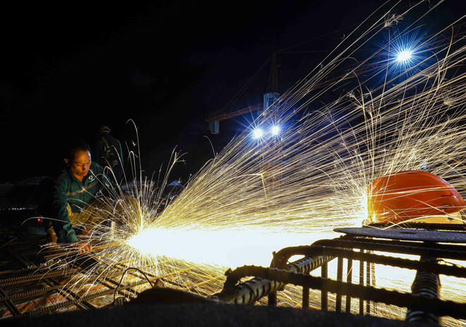 Trên công trường xây dựng Trường Liên cấp Tiểu học – Trung học cơ sở xã Si Pa Phìn (tỉnh Điện Biên) - trường khởi công đầu tiên trong số 100 trường, hơn 400 công nhân chia ca làm việc xuyên ngày đêm để kịp tiến độ. (Ảnh: Xuân Tư/TTXVN).