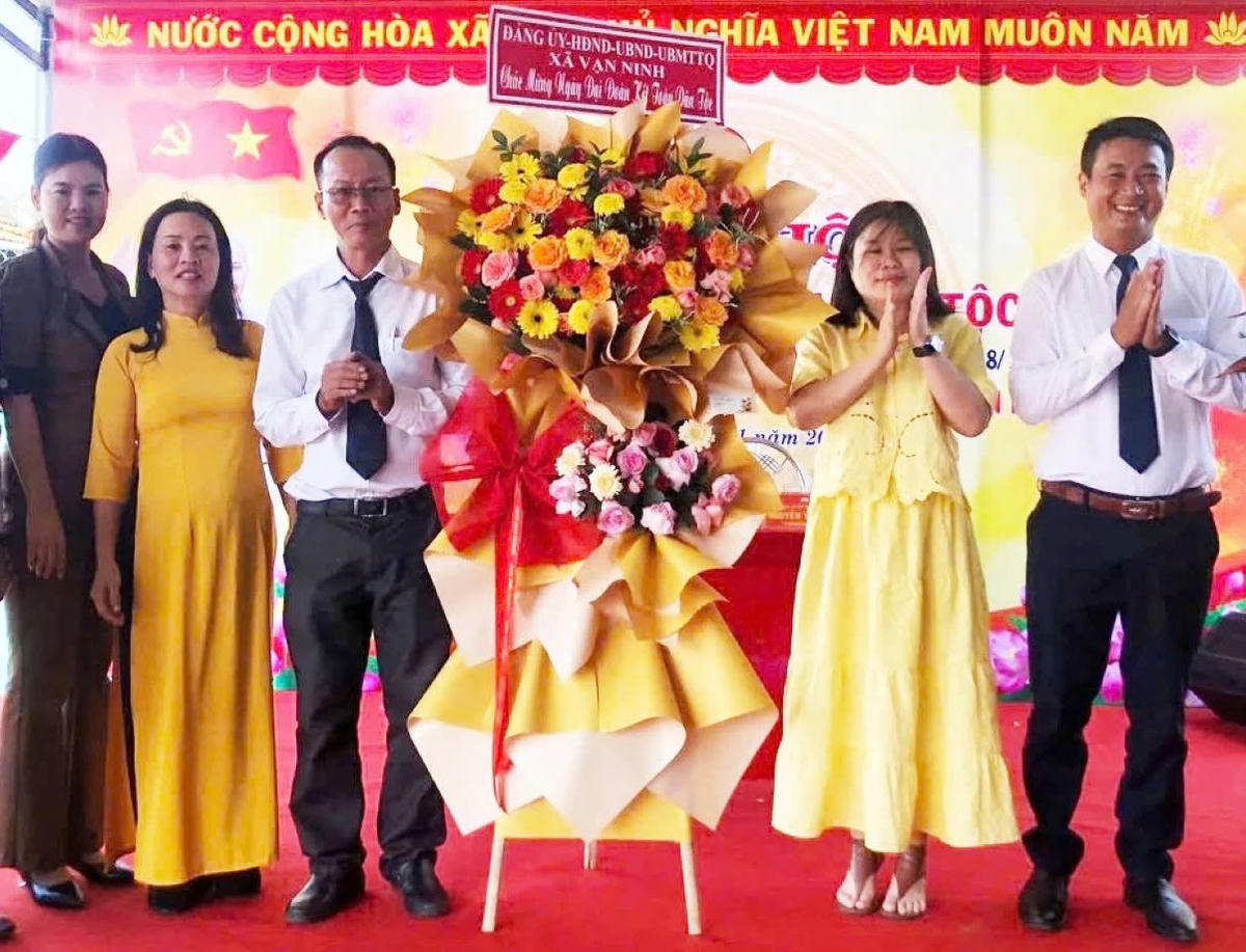 Tặng hoa chúc mừng Ngày hội Đại đoàn kết toàn dân tộc liên thôn Tân Phú - Vinh Huề. Ảnh: H.D.