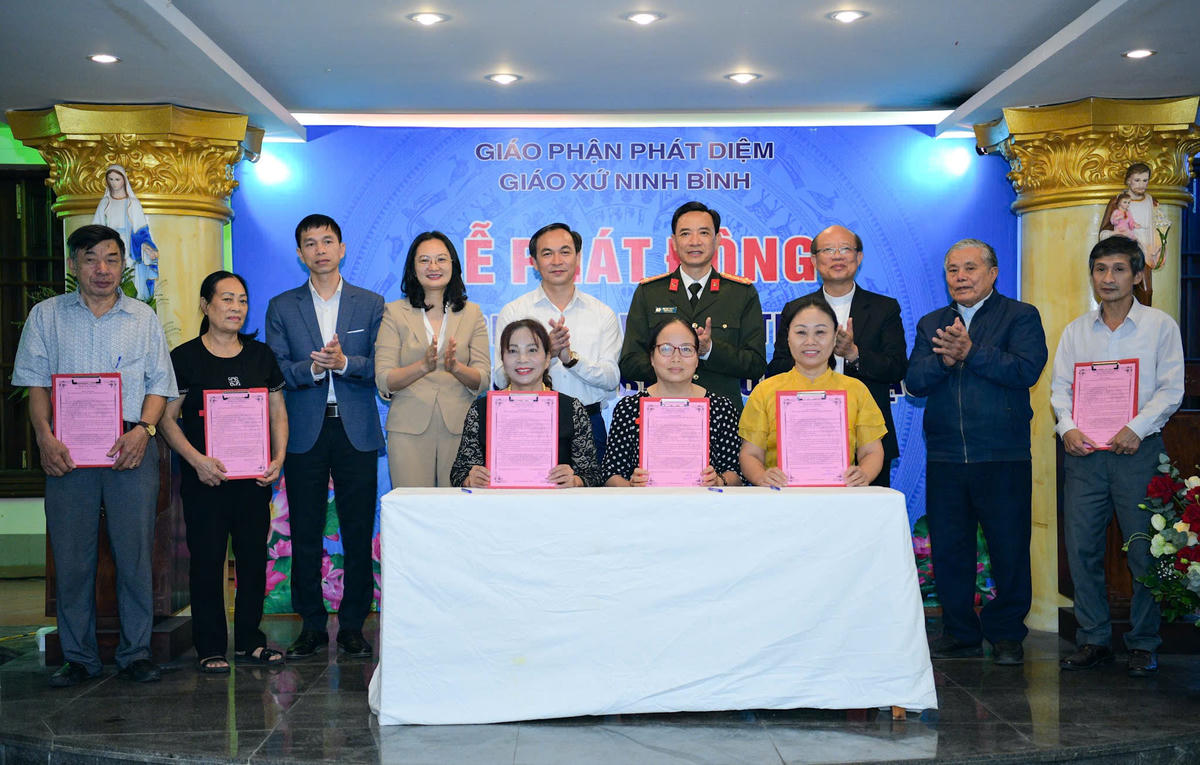 Đại diện các hộ gia đình ký cam kết với Giáo xứ Ninh Bình về bảo vệ môi trường, ứng phó với biến đổi khí hậu. Ảnh: Đình Minh