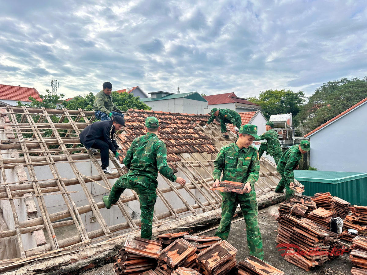 Những chiến sỹ trẻ lợp lại mái nhà bà Đo. Ảnh: Nguyễn Quý.