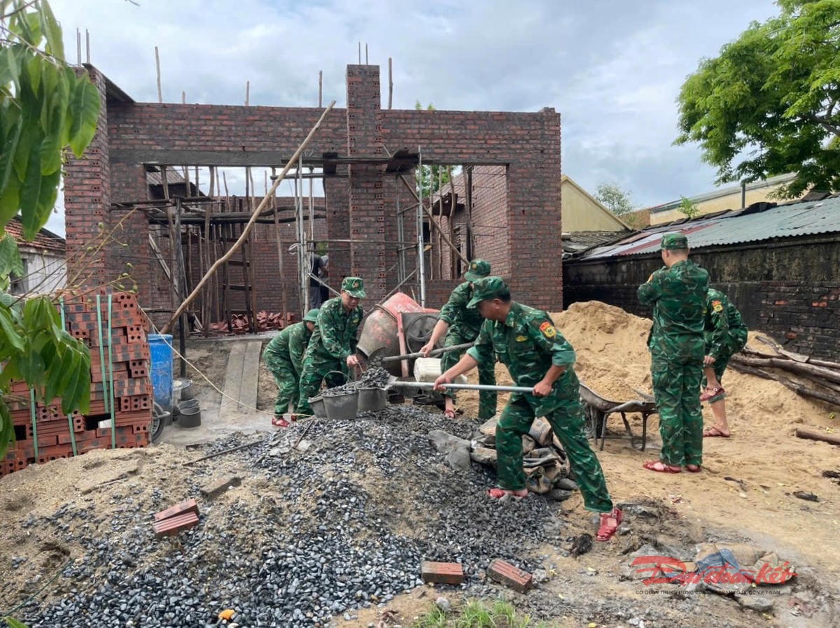 Cán bộ, chiến sĩ Đồn Biên phòng Trà Cổ giúp xây dựng nhà cho gia đình bà Vũ Thị Tâm. Ảnh: Nguyễn Quý.