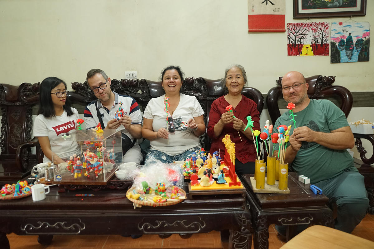 Du khách quốc tế thích thú khi cầm trên tay những sản phẩm tò he. Ảnh: Như Quỳnh.