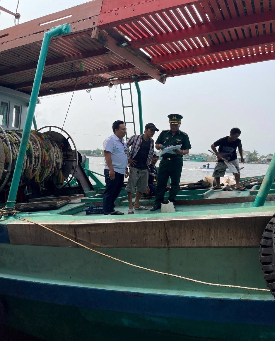 Nhân viên cảng cá phối hợp với Bộ đội Biên phòng kiểm tra tàu cá cập cảng. Ảnh: Nguyên Du