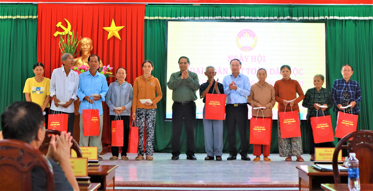Thủ tướng Phạm Minh Chính tặng quà cho người dân khu dân cư Thắng Kiên, xã Đề Gi. Ảnh: Tấn Thành.