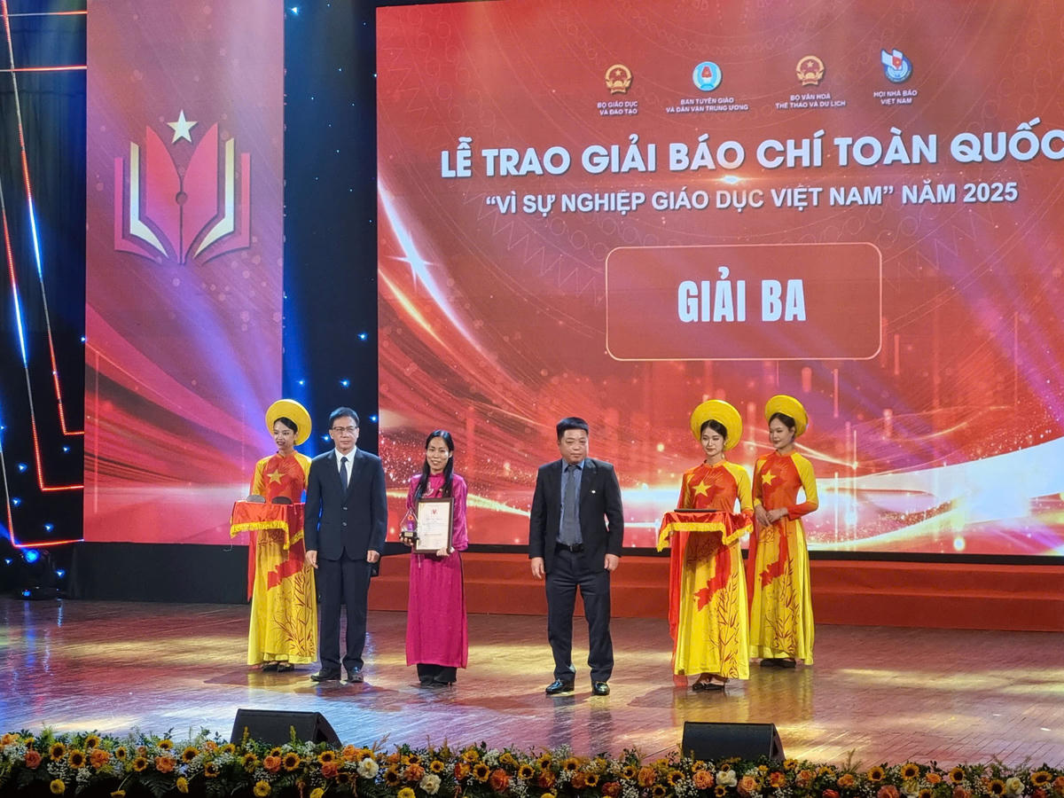 Đại diện nhóm tác giả của Báo Đại đoàn kết lên nhận giải Ba 