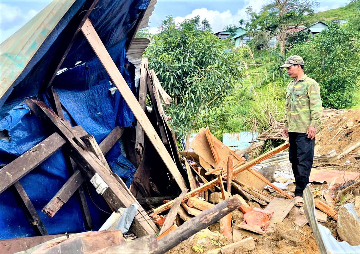 Ông Hồ Văn Phong đứng lặng nhìn ngôi nhà tan hoang sau sạt lở. Ảnh: Tấn Thành.