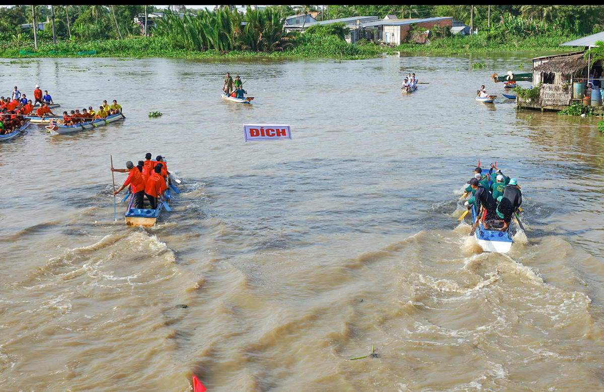 Hoạt động bơi đua vỏ lãi composite dù gần gũi với đời sống miẹt vườn nhưng người dân vẫn đứng hai bên bờ kênh cuồng nhiệt reo hò, vỗ tay cổ vũ vui như ngày hội. Ảnh Nguyễn Minh.