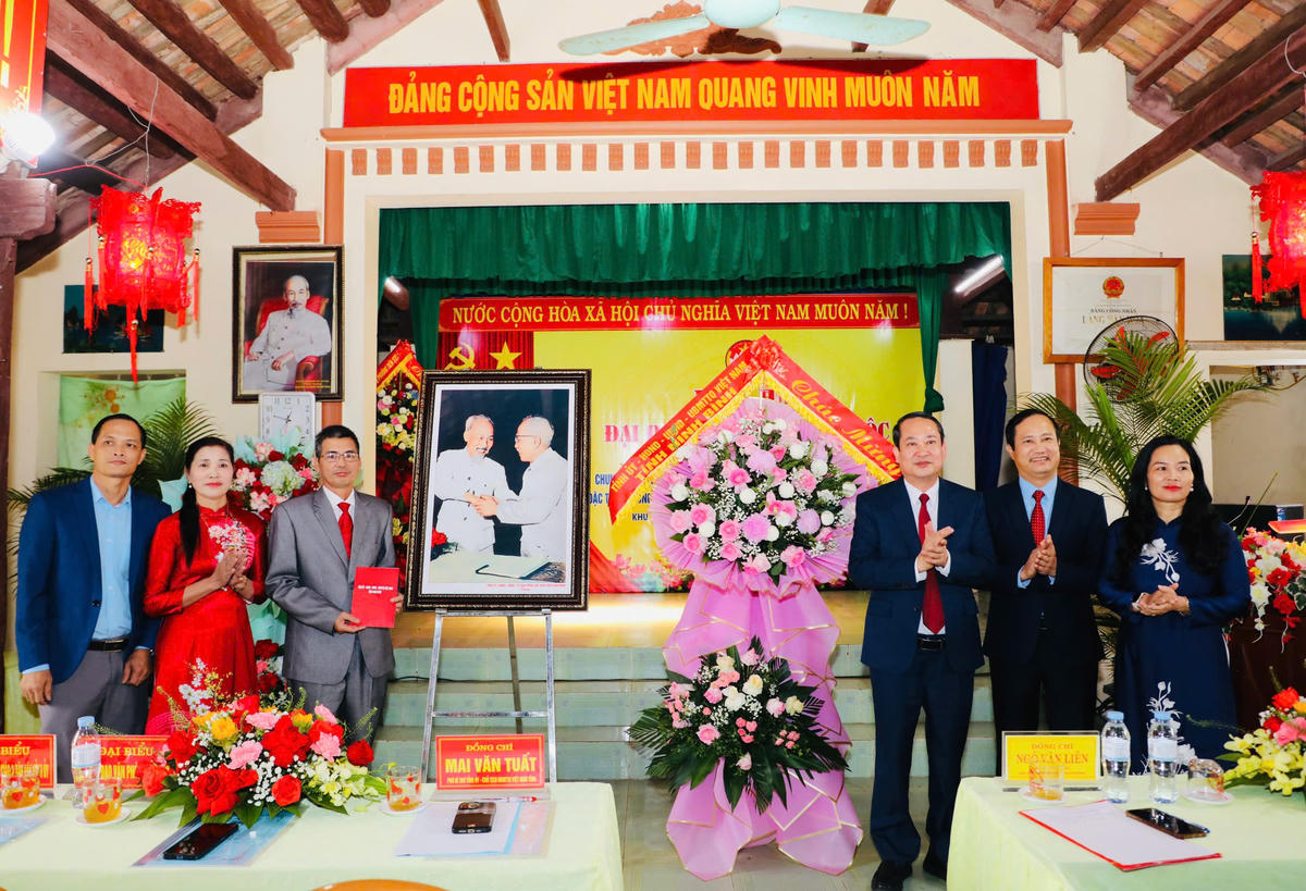 Ông Mai Văn Tuất tặng hoa và bức ảnh Bác Hồ và Bác Tôn bắt tay kết đoàn cho TDP Ngô Tân. Ảnh: Đ.L