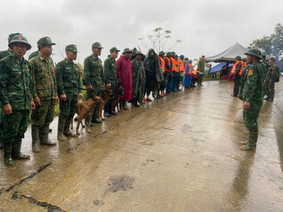 Lực lượng chức năng cùng chó nghiệp vụ triển khai công tác tìm kiếm nạn nhân mất tích. Ảnh: CV.