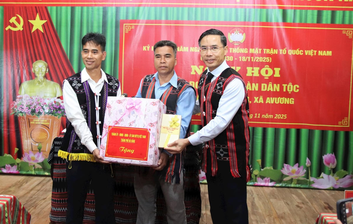 Chủ tịch UBND TP Phạm Đức Ấn (bên phải) tặng quà cho đại diện Ban nhân dân thôn Ta Lang. Ảnh: CV.