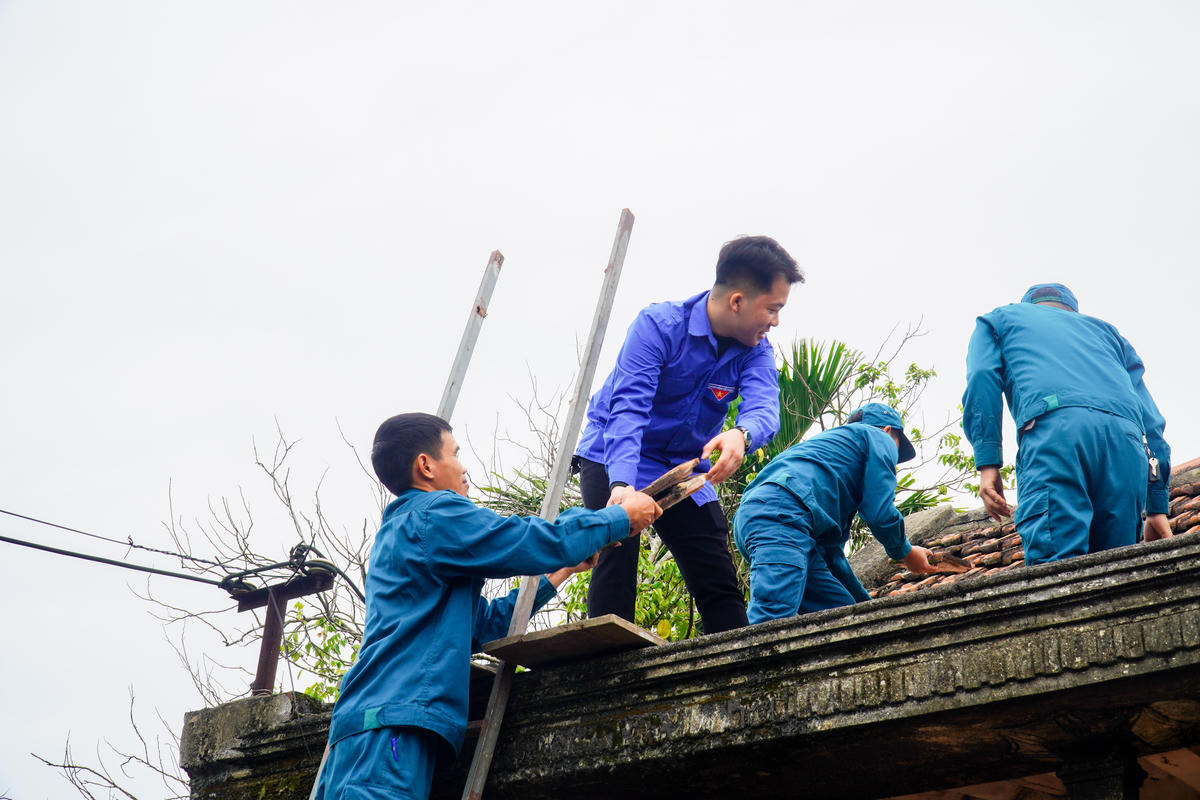 Lực lượng dân quân tự vệ, đoàn viên thanh niên hỗ trợ tháo dỡ ngôi nhà cũ của gia đình bà Xuân ngay sau lễ động thổ. Ảnh: Đình Minh