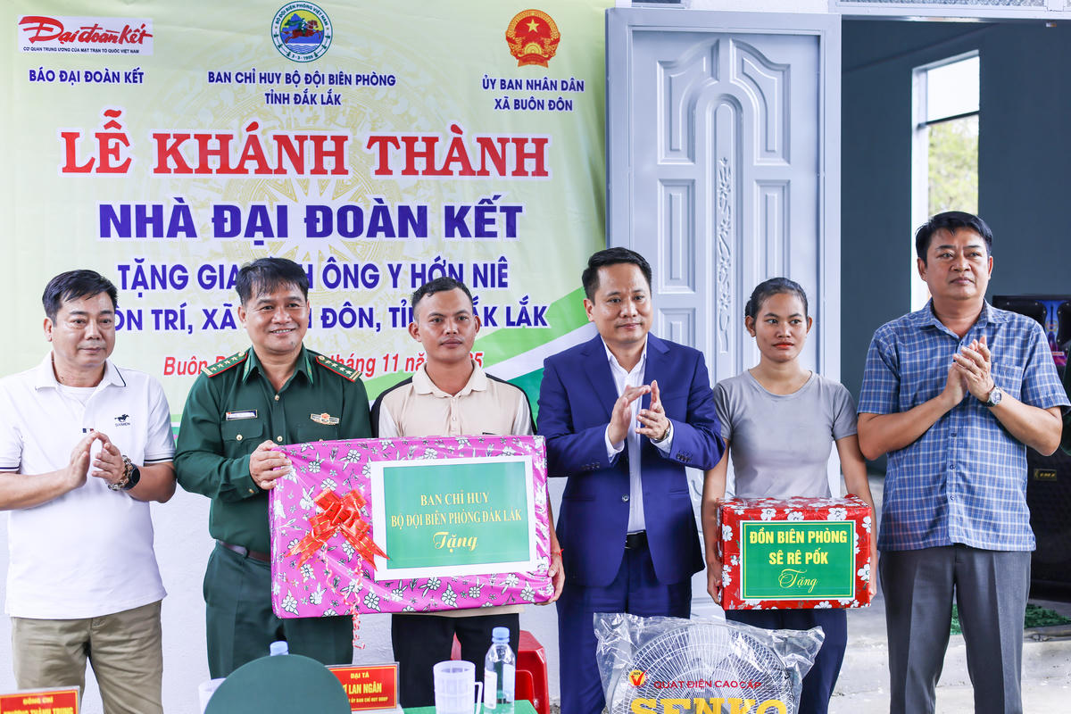 Nhà báo Trương Thành Trung, Tổng Biên tập Báo Đại đoàn kết và Đại tá Rơ Lan Ngân, Phó Chính ủy Bộ Chỉ huy Bộ đội Biên phòng tỉnh Đắk Lắk tặng quà cho gia đình ông Y Hớn Niê. Ảnh: Quang Vinh.