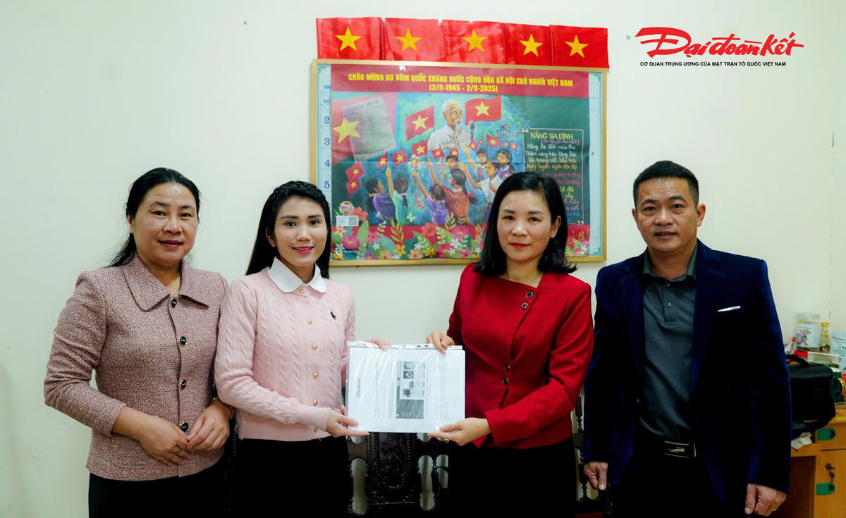 Phóng viên Báo Đại đoàn kết gửi tài liệu Chương trình "Vinh danh Người truyền lửa" cho đại diện Ủy ban MTTQ Việt Nam tỉnh Hà Tĩnh. Ảnh: Cẩm Kỳ.