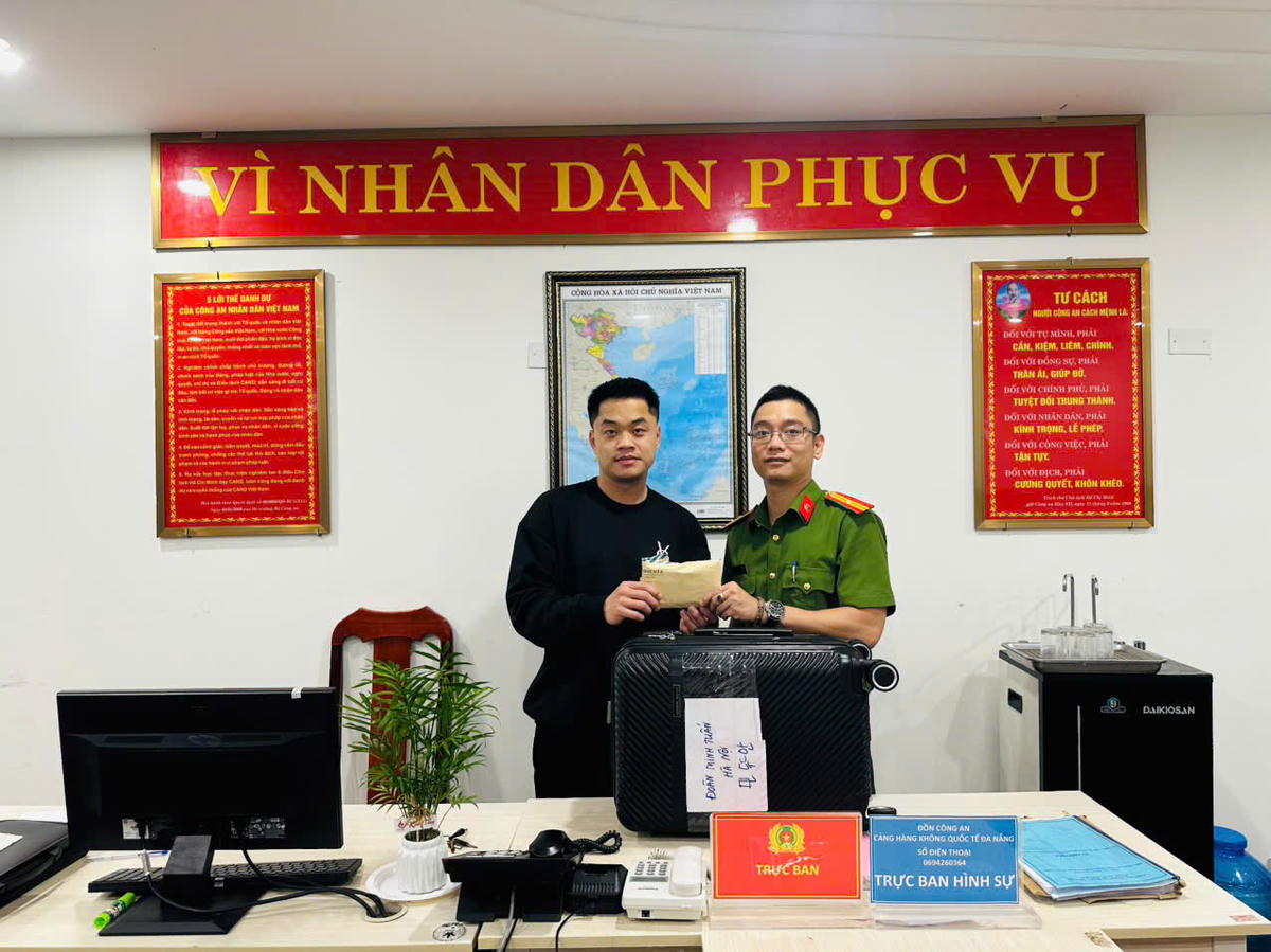 Du khách Đoàn Minh Tuấn nhận lại va li. Ảnh: Nguyễn Tú.