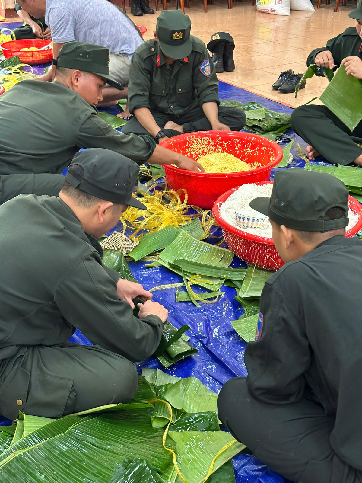 Lực lượng công an tham gia gói bánh chưng. Ảnh: SĐ.
