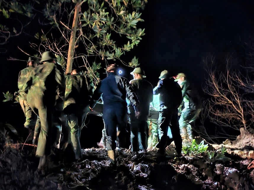 Các lực lượng biên phòng, dân quân xã La Êê vượt điểm sạt lở đưa sản phụ đi cấp cứu trong đêm. Ảnh: CV.