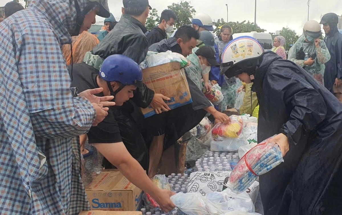 Nhiều người dân chung tay vận chuyển nhu yếu phẩm cho người dân vùng lũ. (ảnh X.H)