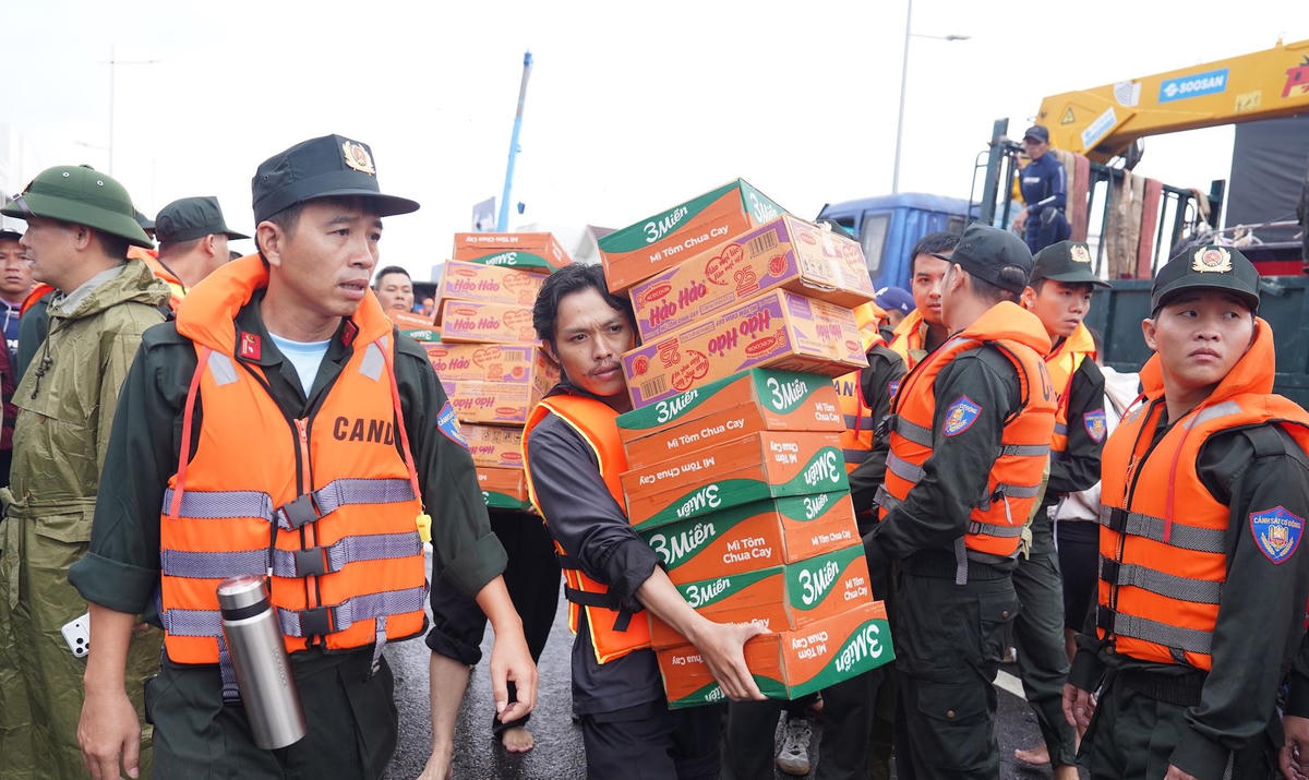 Tiếp tế nhu yếu phẩm cho người dân ở trong khu vực ngập lụt. (ảnh Đ.L)