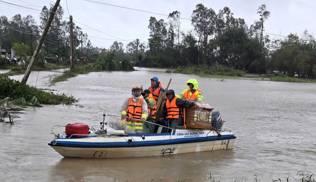 CSGT vượt lũ, đưa quan tài để gia đình kịp mai táng cháu bé. Ảnh: CA.