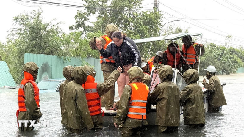 Công an dùng ca nô ứng cứu người dân phường Tuy Hoà bị ngập lũ. (Ảnh: Tường Quân/TTXVN).