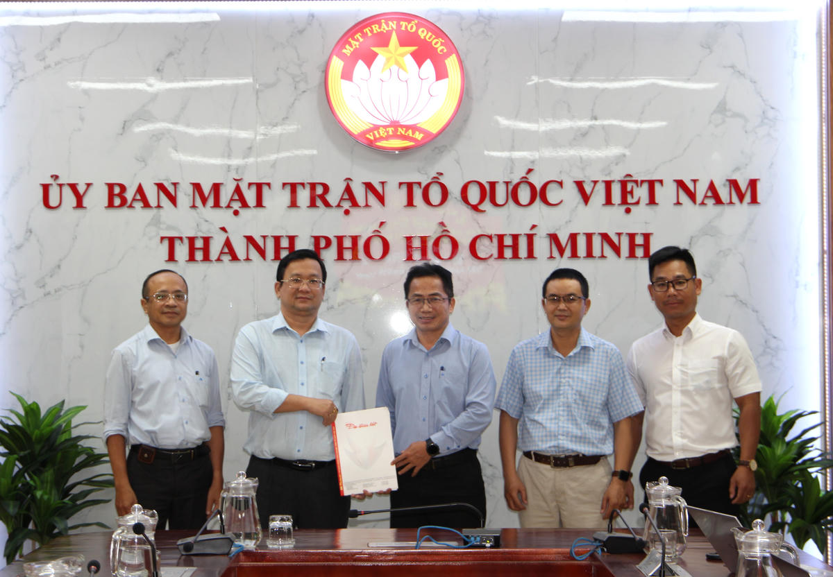 Nhà báo Chu Ninh, Trưởng Ban Đại diện Báo Đại Đoàn kết tại TP Hồ Chí Minh trao tài liệu về Giải thưởng "Vinh danh Người truyền lửa" tới ông Phan Hồng Ân – Phó Chủ tịch Uỷ ban Mặt trận Tổ quốc Việt Nam TP Hồ Chí Minh. Ảnh: Q.Đ.