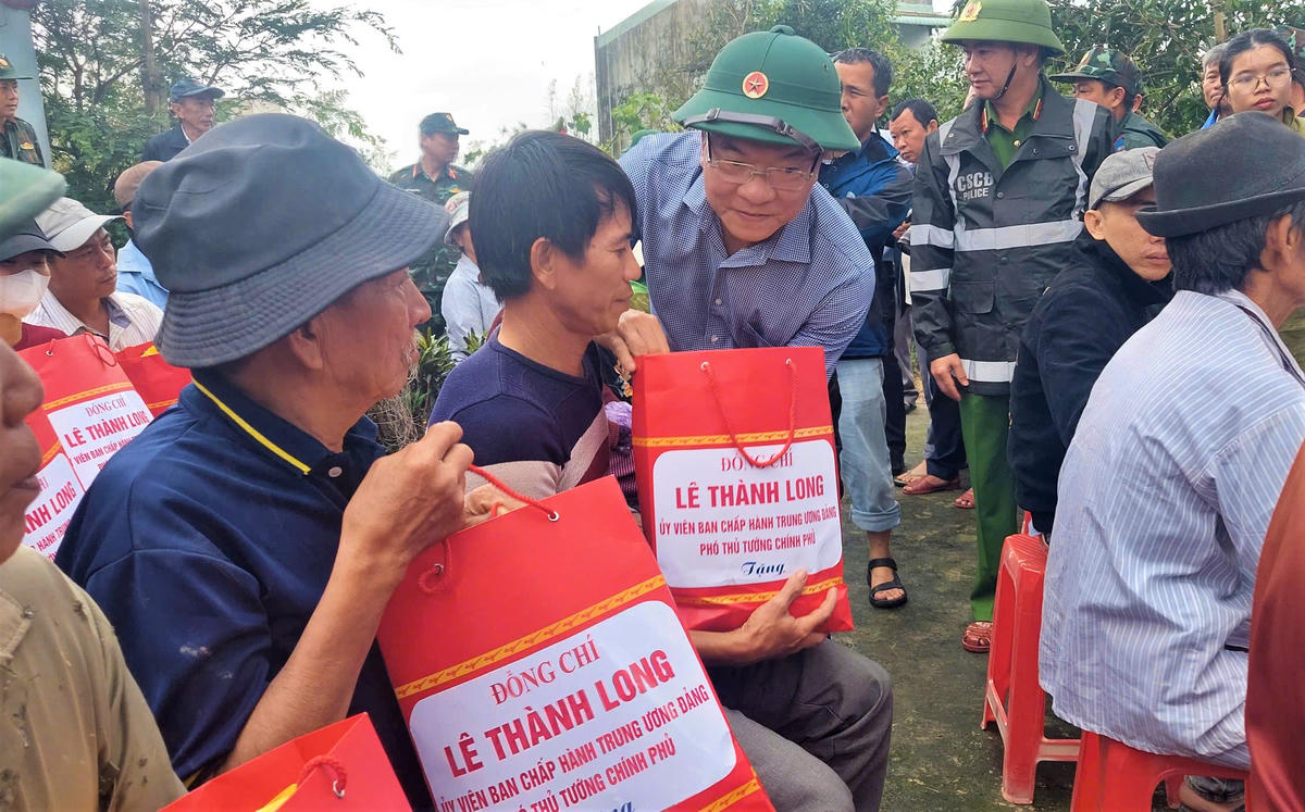 Phó Thủ tướng Lê Thành Long tặng quà cho bà con vùng lũ ở xã Tuy Phước. Ảnh: Chí Đại.