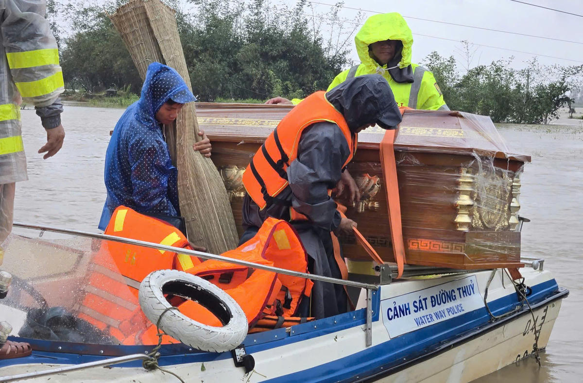 Lực lượng CSGT&nbsp;vượt hơn một giờ đồng hồ qua dòng nước lũ chảy mạnh để đưa quan tài cháu bé về đến nơi an toàn. Ảnh:CA.