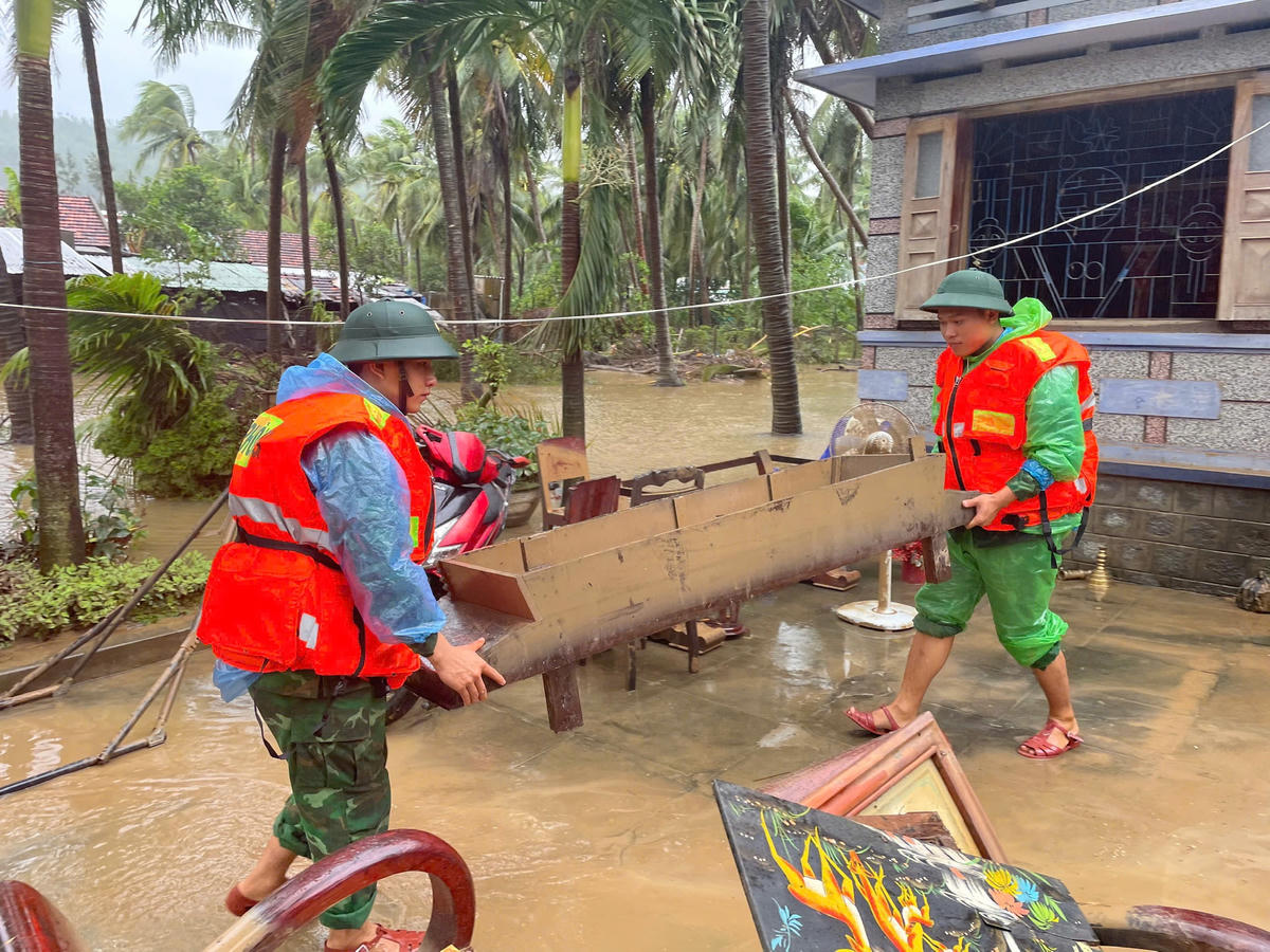 Cán bộ, chiến sĩ Đồn Biên phòng Xuân Đài phối hợp với lực lượng địa phương thu dọn bùn đất, vệ sinh môi trường, hỗ trợ nhân dân khắc phục thiệt hại sau mưa lũ. Ảnh: Thùy Dung.