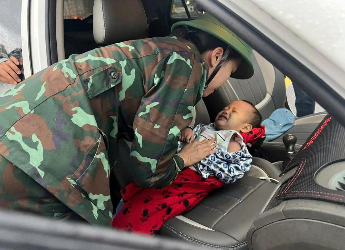 Cán bộ, chiến sĩ của Bộ CHQS tỉnh Gia Lai đưa gia đình và cháu bé vùng ngập lũ đến cơ sở y tế điều trị an toàn. Ảnh: CV.