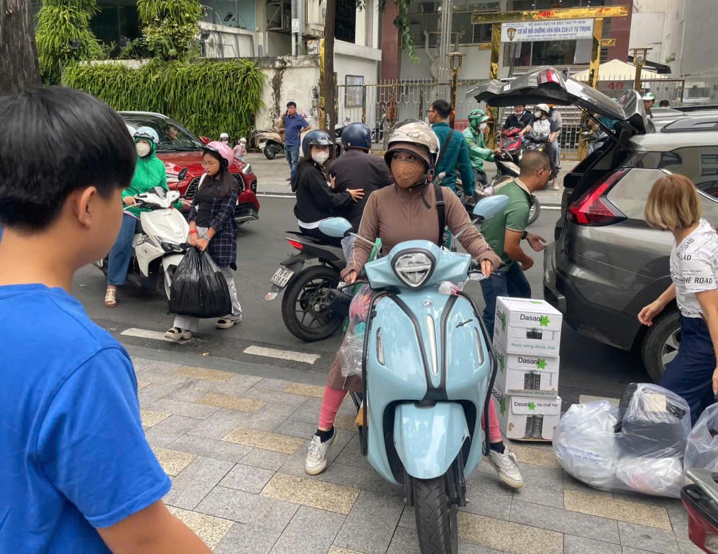 Tranh thủ ghé ủng hộ đồng bào trước khi đi làm. Ảnh: Q.Đ.