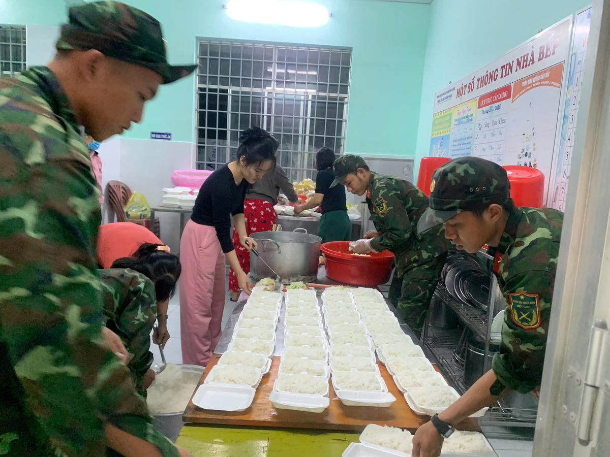 Bộ đội Trung đoàn 584 cùng người dân chuẩn nhanh chóng chuẩn bị cơm tối cho những người dân đang bị cô lập. (ảnh Đ.S)
