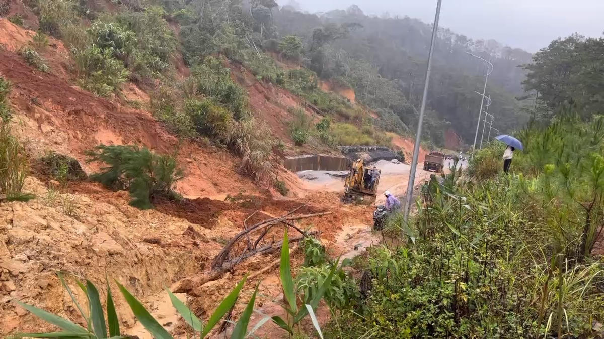Lực lượng chức năng huy động phương tiện khắc phục điểm sạt lở đất đá trên quốc lộ 24. Ảnh: CV.
