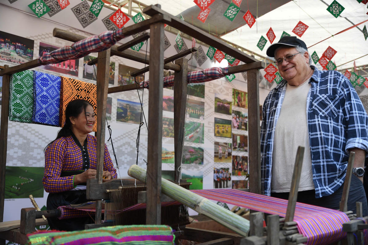 Du khách nước ngoài xem nghệ nhân người Mường dệt vải. Ảnh: Phạm Sỹ.