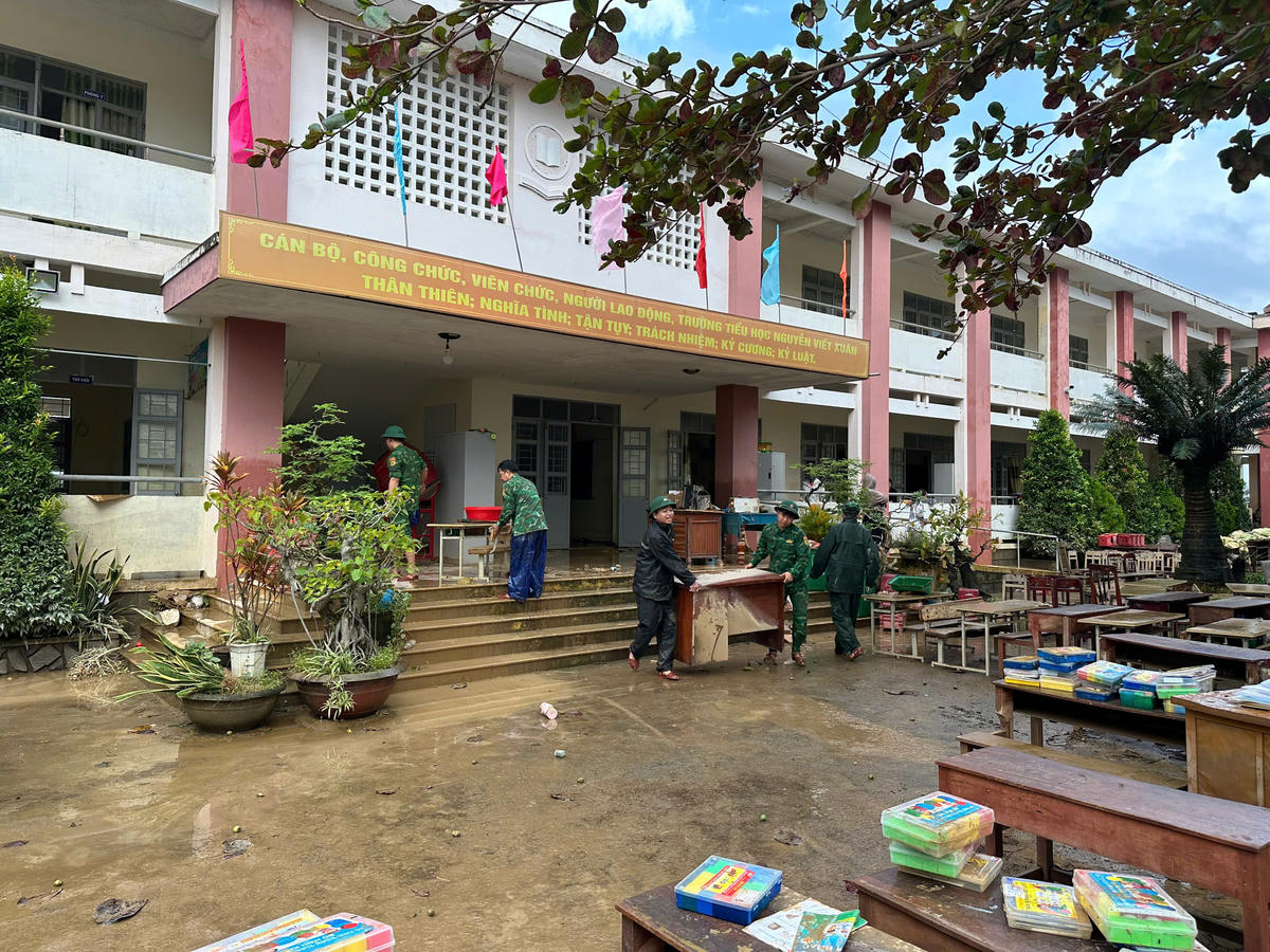 Bộ đội Biên phòng giúp nhà trường sắp xếp lại bàn ghế. Ảnh: Ngọc Lân.