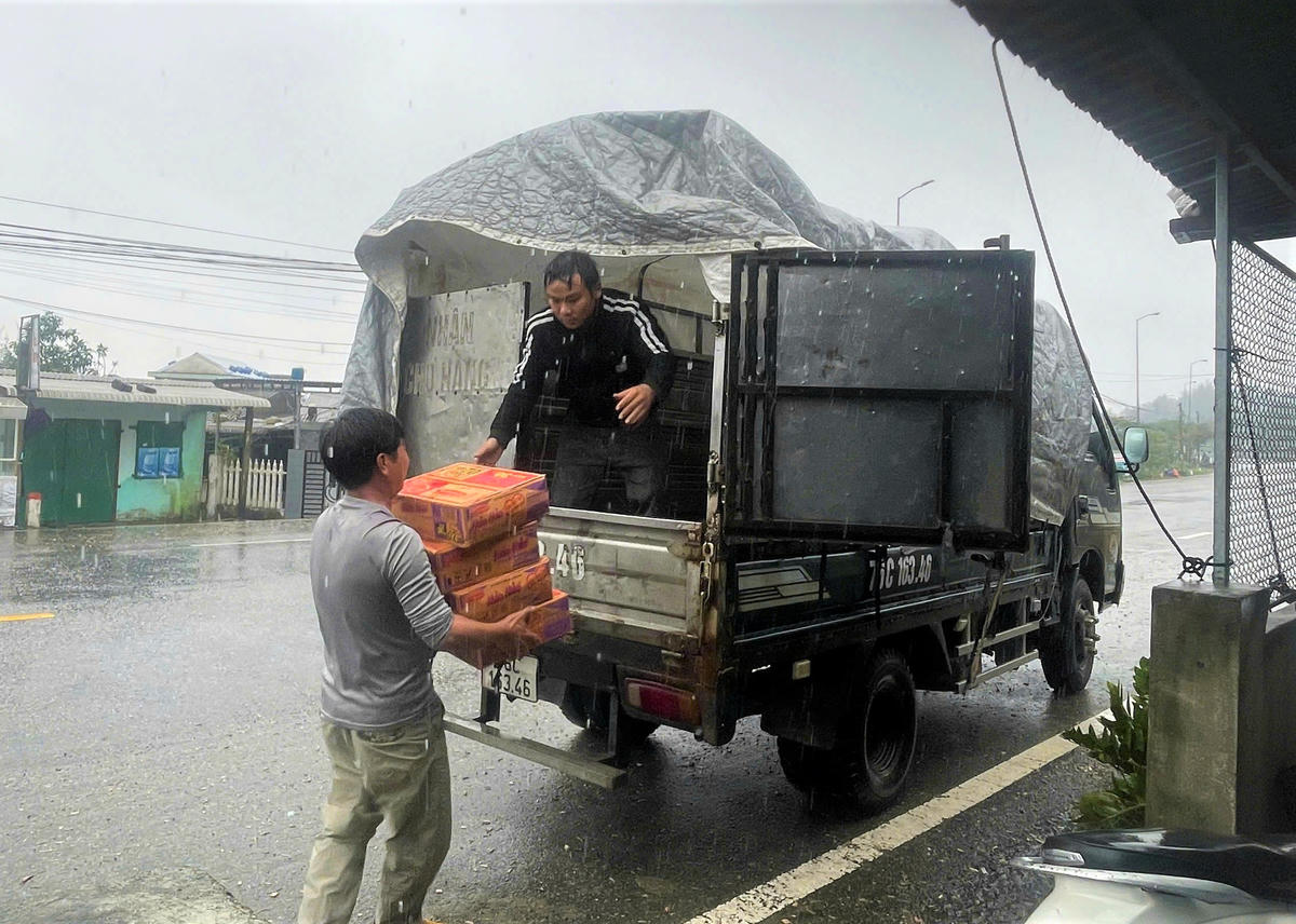 Người dân đưa nhu yếu phẩm lên xe tải vận chuyển vào tỉnh Đắk Lắk và Gia Lai trao tặng đồng bào vùng lũ. Ảnh: CV

