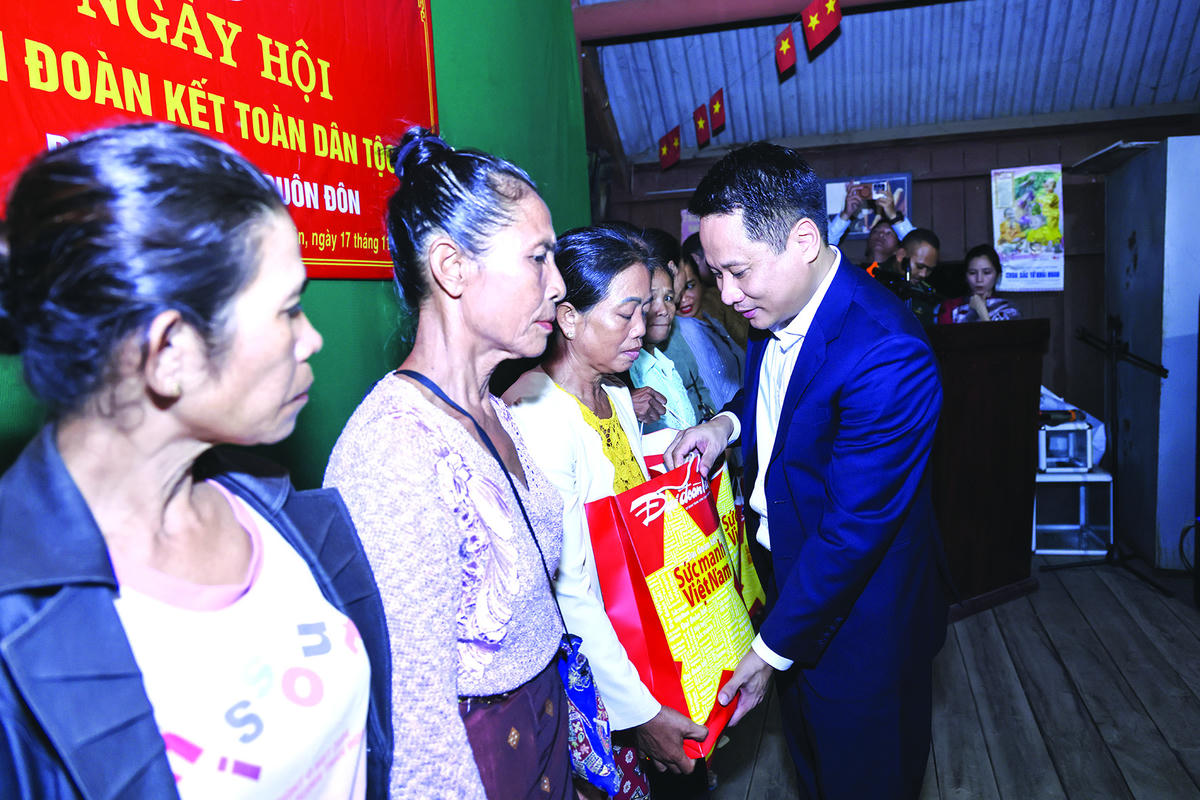 Nhà báo Trương Thành Trung - Tổng Biên tập Báo Đại đoàn kết tặng quà cho các hộ nghèo.