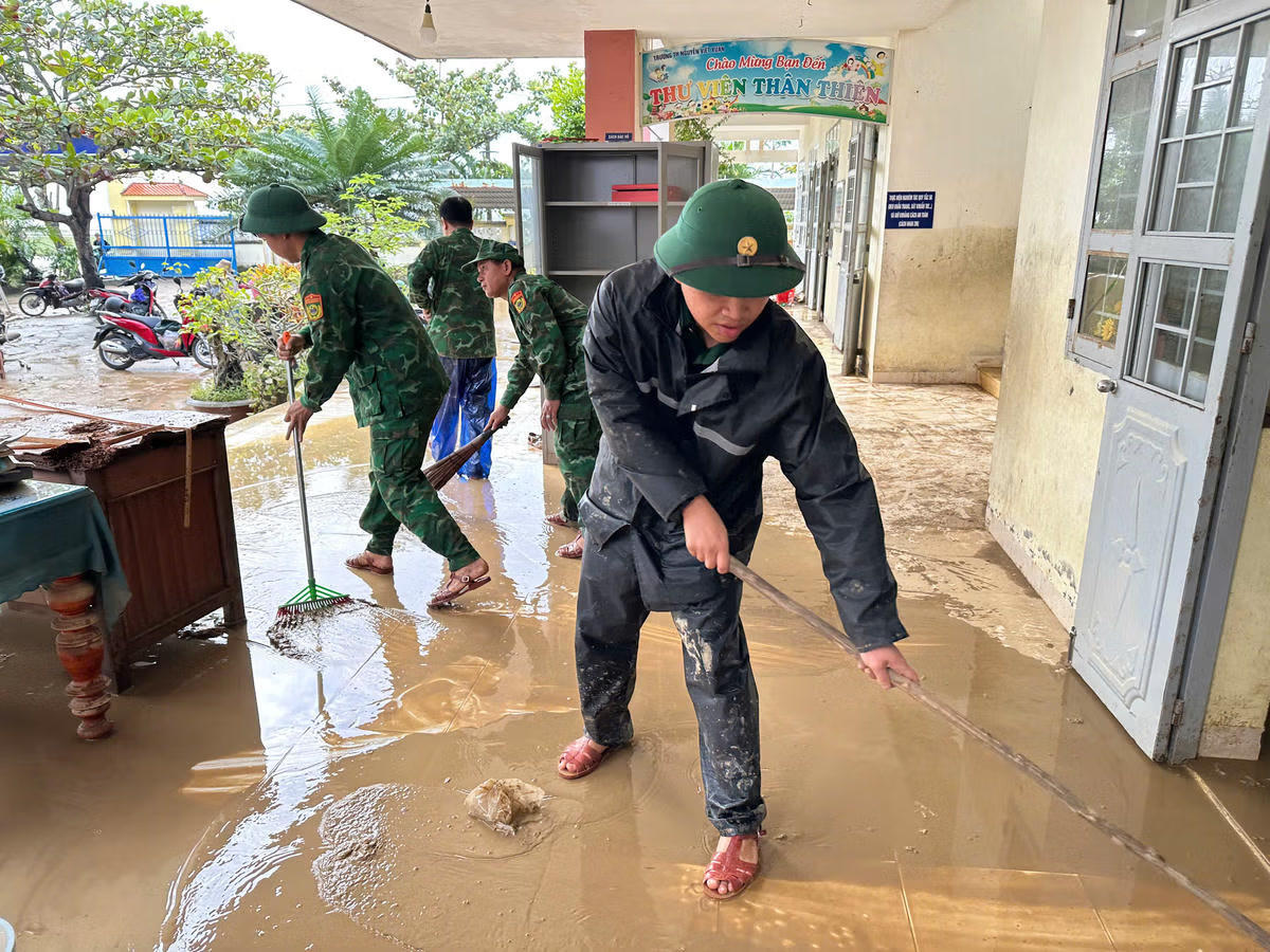 Bộ đội Biên phòng đang giúp nhà trường dọn bùn đất. Ảnh: Ngọc Lân.