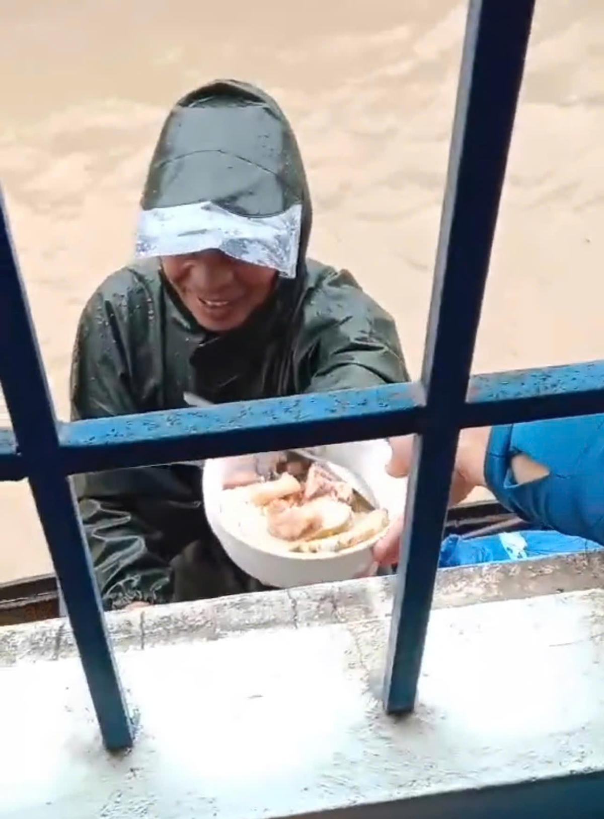 Ông Thạch suốt 2 ngày, 2 đêm trên chiếc xuồng nhỏ lênh đênh trên mặt nước để cứu giúp bà con; người dân ở trên cao thương xót bới cơm cho ông Thạch ăn: BP.